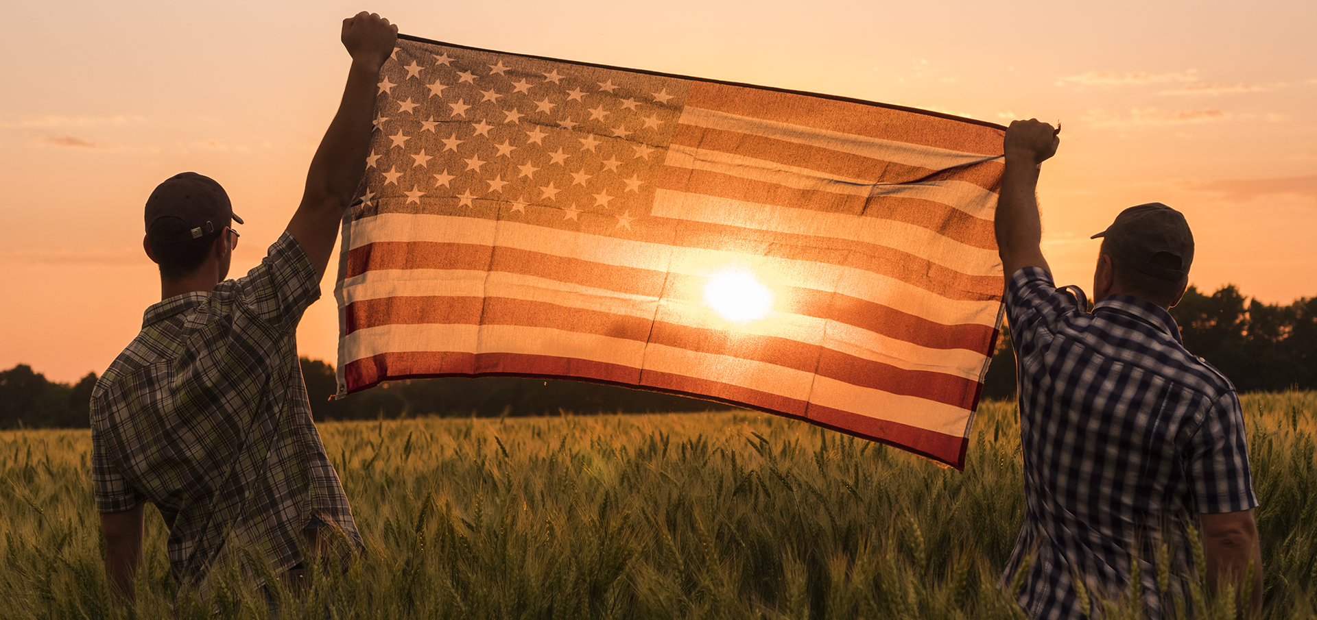 two people holding American flag up
